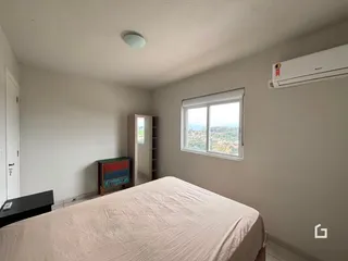 Quarto com cama e janela de vista para a paisagem.