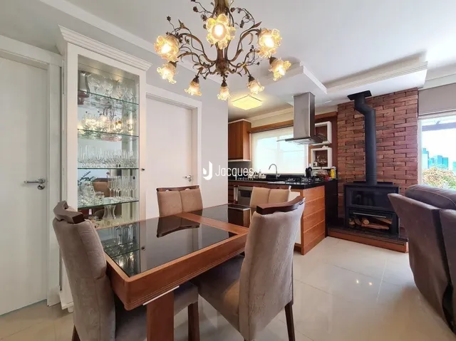Sala de jantar com mesa de vidro e cadeiras de madeira.