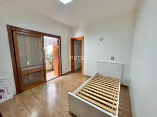 Interior de uma sala com piso de madeira e portas de madeira.