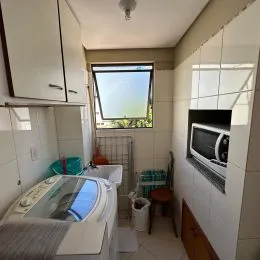 Foto interna de um quarto com paredes brancas e janela.