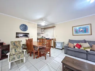Ambiente interno de sala de jantar e cozinha com piso de cerâmica.