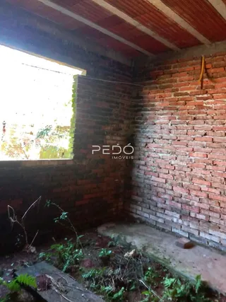 Parede de tijolo aparente de uma residência com janela.