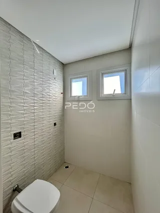 Banheiro com revestimento cerâmico nas paredes.