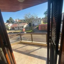Varanda com piso de cerâmica e vista para a paisagem externa.
