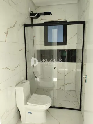 Foto de um banheiro com box de vidro e vaso sanitário.
