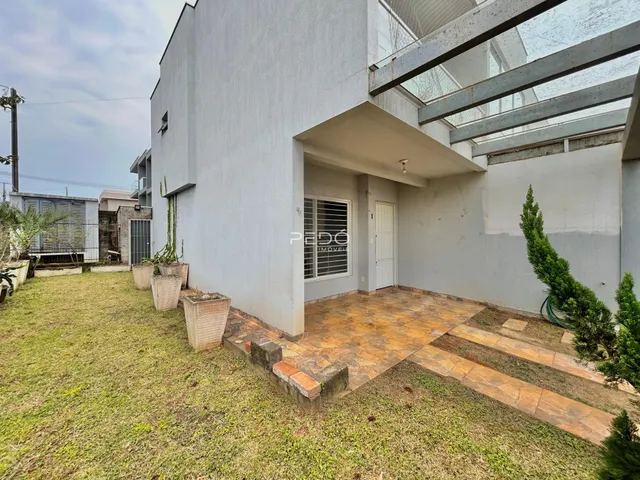 Fachada de uma residência em Lajeado, Brasil, com jardim e área externa pavimentada.