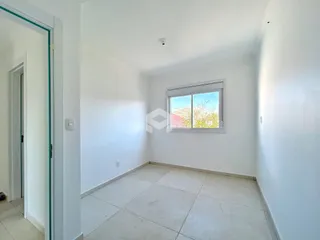Vista interna de um ambiente com paredes brancas e piso de cerâmica.