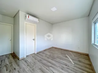 Foto de um ambiente interno com piso de madeira clara e paredes brancas.