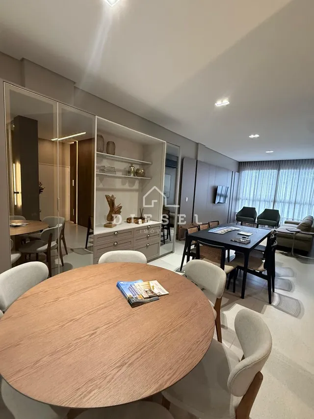 Mesa redonda de madeira em um ambiente interno claro.