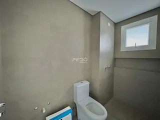 Foto de um banheiro interno com piso e paredes em tom neutro.