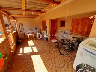 Ambiente interno de uma sala com piso de cerâmica e forro de madeira.