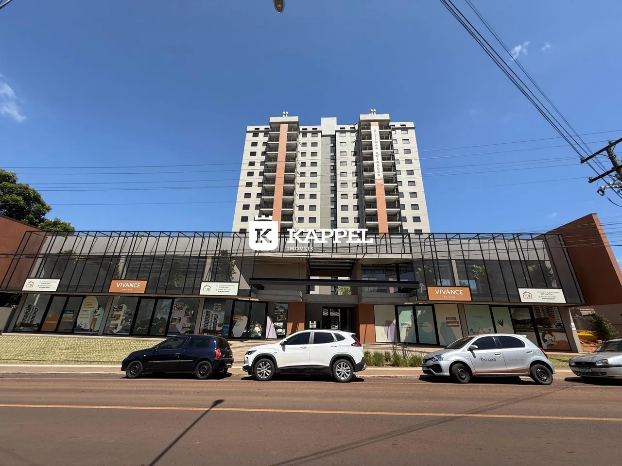 Fachada de um prédio residencial moderno com lojas no térreo em Lajeado, Brasil.