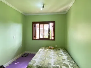 Quarto com paredes verdes e cama coberta com tecido verde.