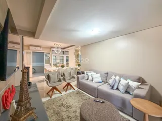 Sala de estar com sofá e poltronas em um ambiente claro.