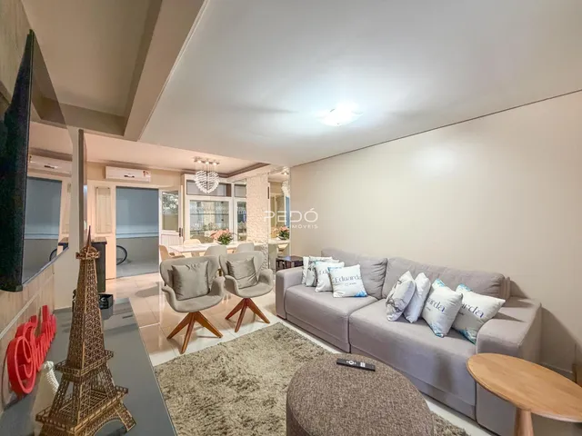 Sala de estar com sofá e poltronas em um ambiente claro.