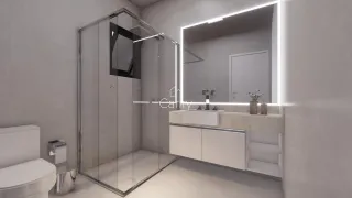 Banheiro moderno com box de vidro e bancada clara.