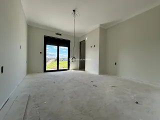Foto de um ambiente interno com paredes brancas e piso de concreto.