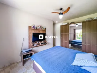 Uma foto de um quarto com cama grande e cabeceira de madeira.