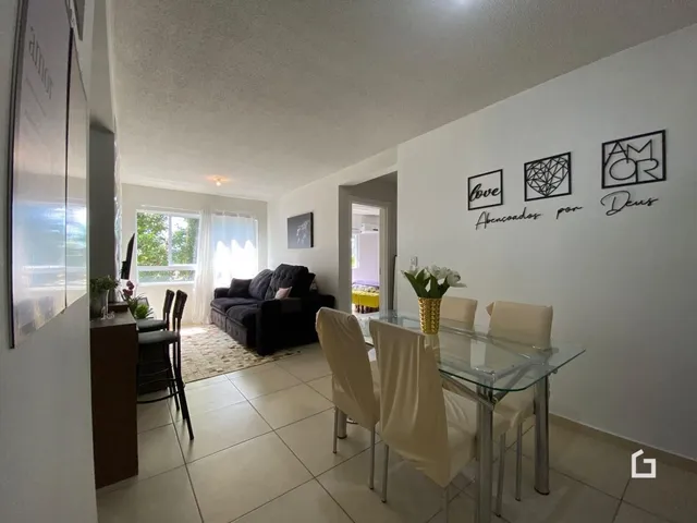 Sala de jantar e estar com piso de cerâmica clara e paredes brancas.