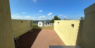 Área externa com piso de cascalho entre paredes amarelas.