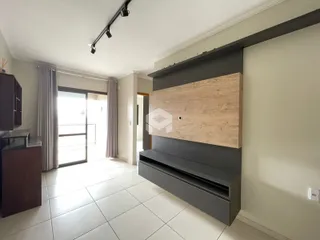 Sala de estar com piso de cerâmica e portas de vidro que dão acesso ao exterior.