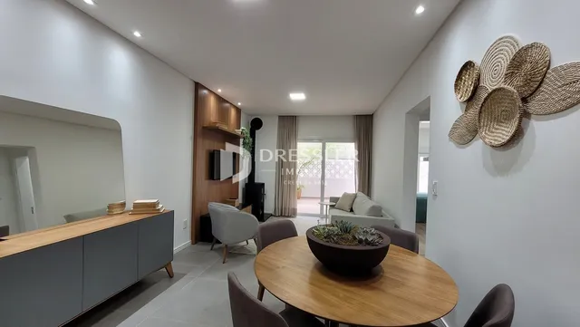 Sala de estar com mesa de madeira e decoração de parede em um imóvel no Brasil.
