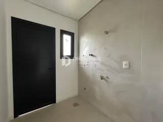 Vista interna de um corredor com porta escura e janela.