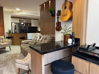 Ambiente de sala de estar com decoração de madeira e área de cozinha em Lajeado.