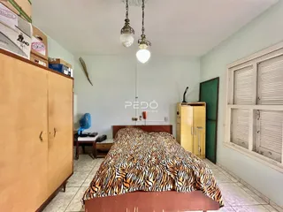 Quarto com cama e guarda-roupa em ambiente residencial.