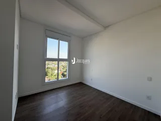 Ambiente interno de uma sala com piso de madeira e janela.