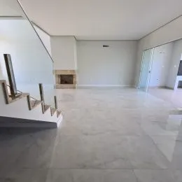 Sala ampla com piso claro e lareira visível.