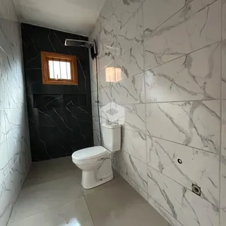 Foto de um banheiro com revestimento em azulejos brancos e detalhes em preto.