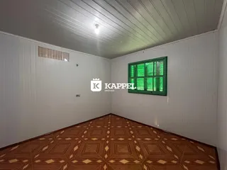 Sala de estar com piso de madeira e paredes brancas.