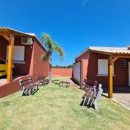 Área externa com gramado e móveis de jardim em uma propriedade.