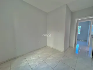 Ambiente interno com piso de cerâmica e paredes brancas.