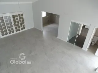 Espaço interno com paredes brancas e piso cinza claro.