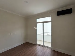 Sala de estar com piso de madeira e porta de vidro.
