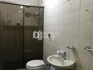 Foto de um banheiro com vaso sanitário e pia de cerâmica.