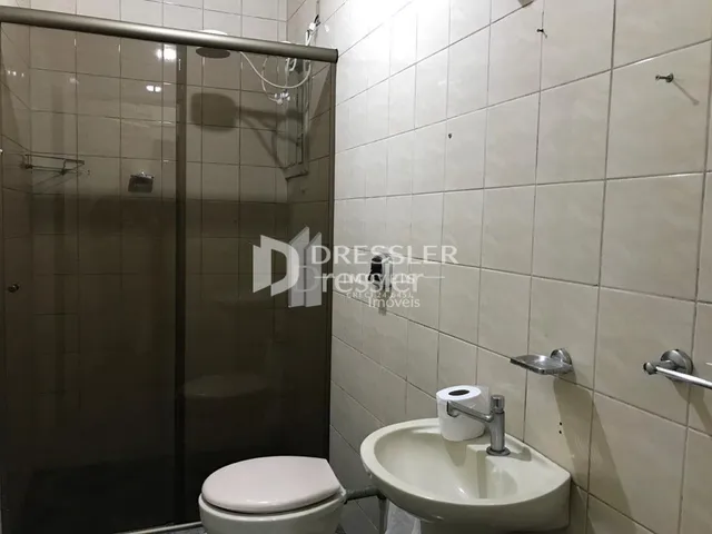 Foto de um banheiro com vaso sanitário e pia de cerâmica.