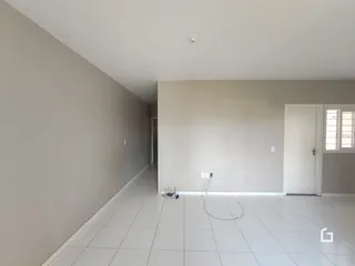 Corredor interno com piso de cerâmica claro.