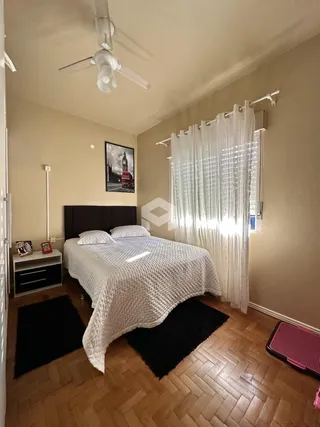 Quarto com cama e janela em ambiente interno.