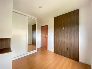 Interior de um corredor com piso de madeira e portas de madeira.