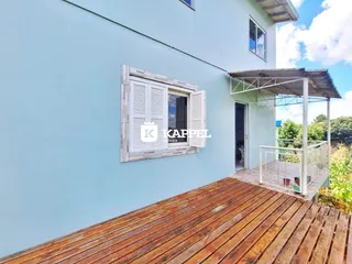Fachada de uma casa em Lajeado, Brasil, com um deck de madeira e área externa.