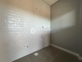 Parede com revestimento de azulejos brancos em um corredor de imóvel.