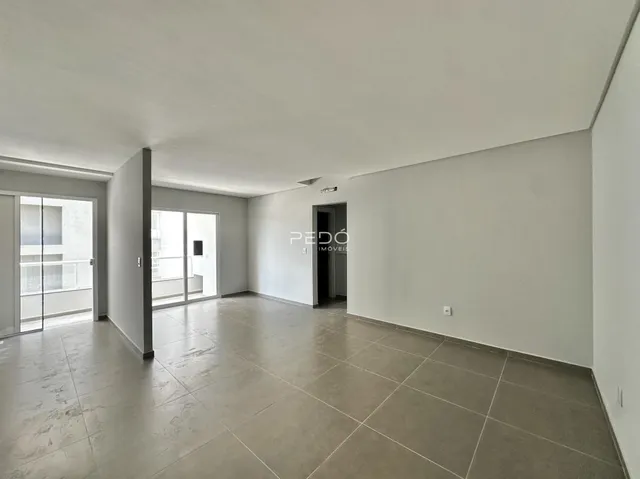 Ambiente interno amplo com piso de cerâmica e portas de vidro.