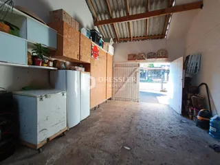 Imagem de um espaço interno com estantes de madeira e armários brancos.