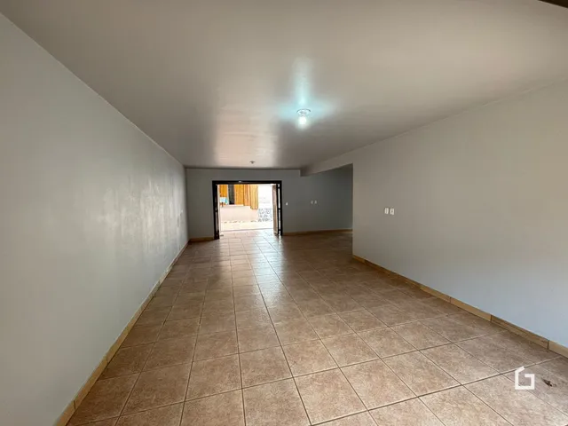 Vista do corredor interno de uma residência com piso de cerâmica.