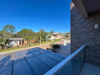 Vista de um terraço com grade de vidro e parede de tijolos em Lajeado, Brasil.