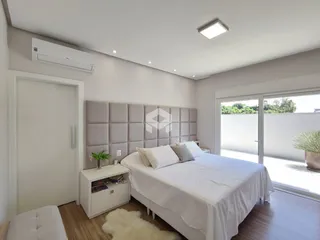 Quarto moderno com cama e porta de vidro.