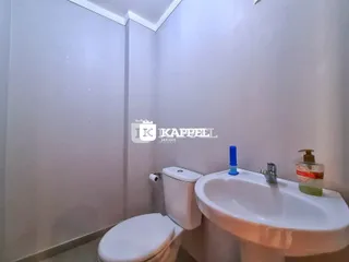 Banheiro com vaso sanitário e pia branca.